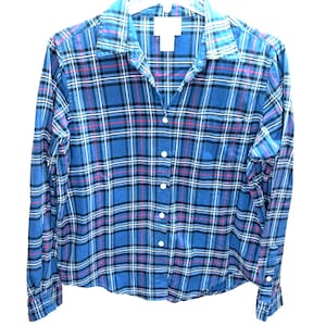 May include: A blue, black, white, and red plaid long-sleeved button-down shirt.