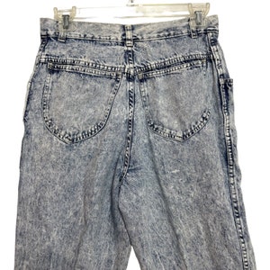 May include: A pair of light blue acid wash denim jeans with a high waist and a relaxed fit. The jeans have a faded look and are made of a soft, comfortable material.