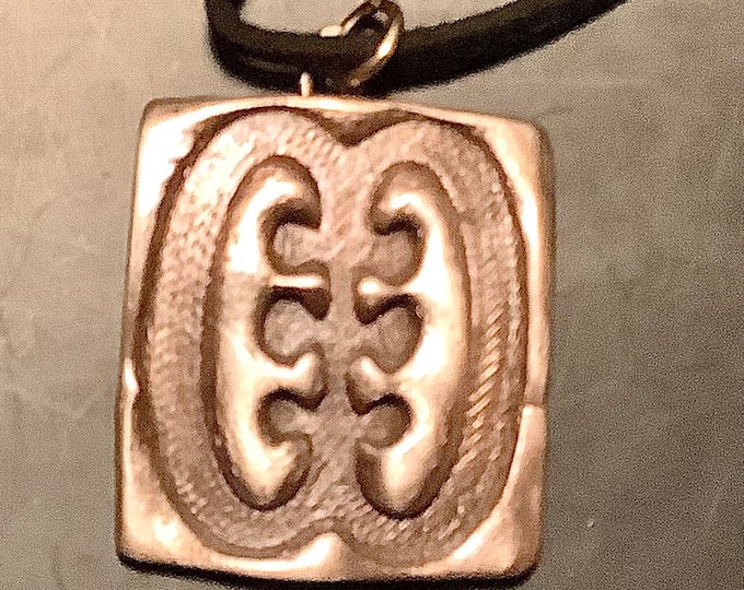 AC17. The Adrinka African language sign that says teeth and the tongue, handmade in bronze, and meaning friendship and interdependence