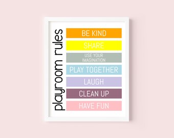 Puede incluir: Una impresión enmarcada en blanco con el texto "playroom rules" en negro en texto vertical en el lado izquierdo. El lado derecho de la impresión tiene una lista de reglas en rayas horizontales de colores: "Be Kind" en naranja, "Share" en amarillo, "Use Your Imagination" en gris, "Play Together" en azul claro, "Laugh" en morado, "Clean Up" en marrón y "Have Fun" en rosa.