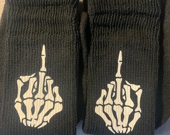 May include: A pair of black socks with a white skeleton hand giving the middle finger printed on each sock.