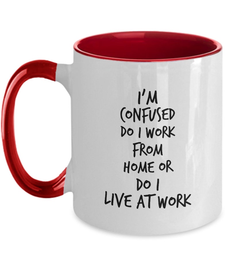 May include: White coffee mug with a red rim and handle. The mug has black text that reads "I'm confused do I work from home or do I live at work."