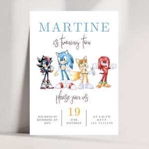 Può includere: Un biglietto d'invito bianco con la scritta "MARTINE is turning tow" in blu e nero. La carta include illustrazioni dei personaggi di Sonic the Hedgehog. La data è il 19 giugno.