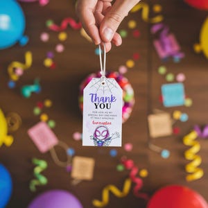 May include: A white thank you tag with a spider-girl cartoon character. The tag has a spider web design and the text "Thank You" with the message "For join me my special day and make it truly amazing! Love Martine".