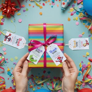 May include: Four colorful thank you tags with a spider-man, hulk, and iron man design. The tags are tied to a rainbow striped gift box with a pink ribbon.