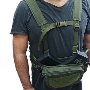 May include: A green tactical chest rig with two magazine pouches and a large front pouch. The rig has adjustable straps and a buckle closure.