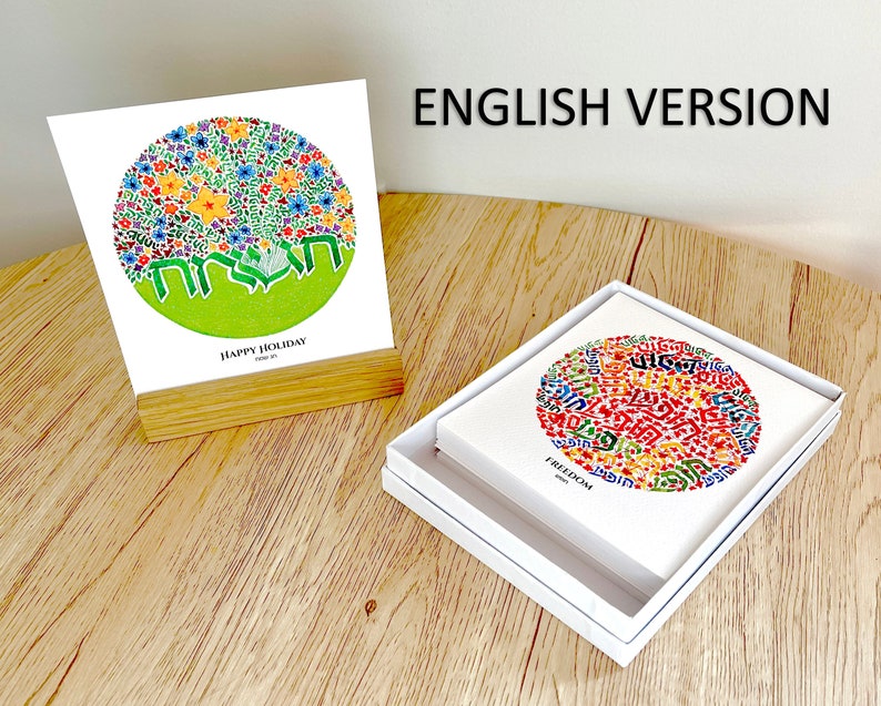 May include: Two versions of a greeting card featuring a circle of colorful flowers and Hebrew text. The card on the left is a white card with the text "Happy Holiday" and the card on the right is a white card with the text "Freedom".