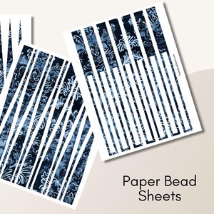May include: Three sheets of paper featuring a dark blue floral design and white vertical stripes. The text "Paper Bead Sheets" is printed in black. The sheets are displayed at various angles against a neutral background.