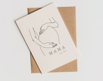 May include: A white card with a line drawing of a pregnant person with their hands on their belly. The text "MAMA to be" is written below the drawing.