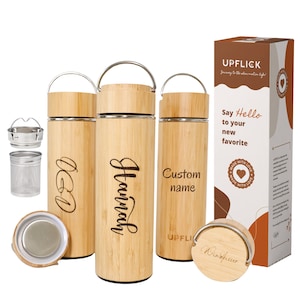 May include: Three bamboo travel mugs with stainless steel lids and a built-in tea infuser. The mugs are engraved with the names "Hannah", "OGD", and "Custom name". The mugs are accompanied by a box with the brand name "UPFLICK" and the text "Say Hello to your new favorite".