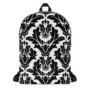 May include: A black and white backpack featuring a repeating damask pattern. The backpack has a top handle, adjustable shoulder straps, and a front pocket. The design is a classic, ornate floral motif, creating a stylish accessory.