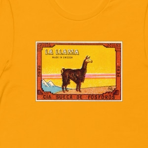 May include: A yellow t-shirt with a vintage matchbox label featuring a llama and the text "LA LLAMA MADE IN SWEDEN PERU CIA SUECA DE FOSFOROS".