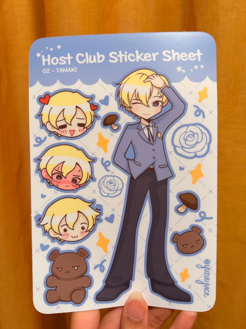 K&ouml;nnte beinhalten: Ein Stickerbogen mit Illustrationen aus der Host Club-Serie. Der Bogen enth&auml;lt eine Ganzk&ouml;rperillustration eines Charakters in einem blauen Anzug sowie kleinere Aufkleber des Gesichts des Charakters und einen braunen B&auml;ren. Der Text "Host Club Sticker Sheet" ist sichtbar.