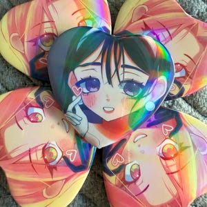 May include: Five heart-shaped holographic stickers featuring anime-style portraits of young women. The stickers have a rainbow sheen and are in shades of pink, yellow, green, and blue. Each sticker has a different facial expression.