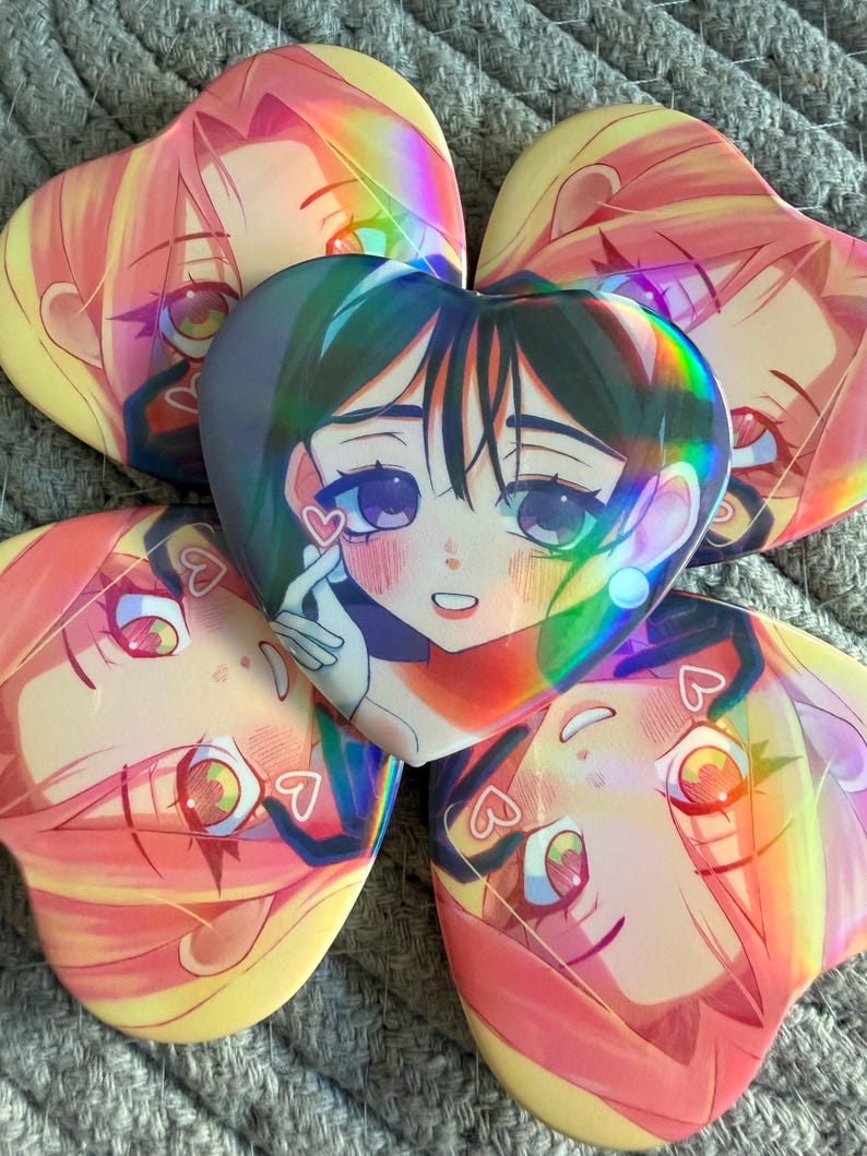 May include: Five heart-shaped holographic stickers featuring anime-style portraits of young women. The stickers have a rainbow sheen and are in shades of pink, yellow, green, and blue. Each sticker has a different facial expression.
