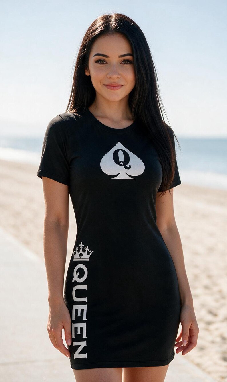 May include: A black t-shirt dress featuring a white spade symbol with the letter Q in the center on the chest. The word QUEEN is printed vertically in white along the right side, topped with a small crown graphic above the letter Q.