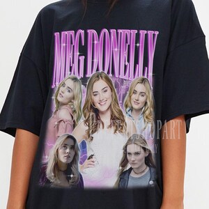 May include: Black oversized t-shirt with a graphic print of a group of women with the text "Meg Donnelly" in pink.
