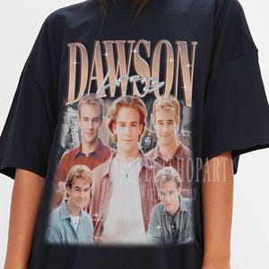 Pode incluir: Camiseta preta oversized com uma estampa gráfica vintage do elenco de Dawson's Creek. A estampa inclui o texto "Dawson 1998" e imagens dos atores.