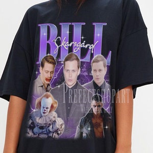 May include: Black oversized t-shirt with a graphic print of Bill Skarsgård as Pennywise from the movie "IT" and other actors from the movie. The text "BILL Skarsgård" is printed in purple on the shirt.