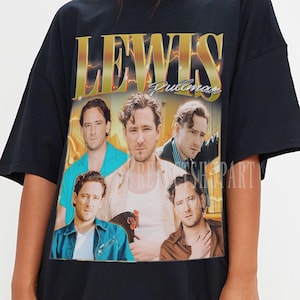 Puede incluir: Camiseta negra de gran tamaño con un gráfico retro de un grupo de hombres y el texto dorado "LEWIS Pullman". El diseño tiene un aspecto vintage descolorido. La camiseta es de estilo unisex y relajado, adecuada para uso casual.