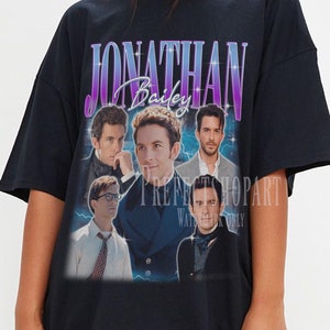 May include: Black oversized t-shirt with a vintage-style graphic print featuring a group of men and the text "JONATHAN Bailey".