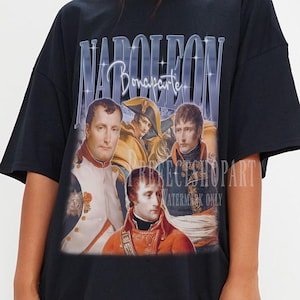 Könnte beinhalten: Schwarzes T-Shirt mit einem Vintage-Grafik von Napoleon Bonaparte. Das Design umfasst Porträts von Napoleon und den Text "NAPOLEON Bonaparte" in einer stilisierten Schriftart. Das T-Shirt hat kurze Ärmel und eine lockere Passform.