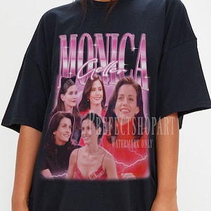 May include: Black oversized t-shirt with a graphic print of the six main characters from the TV show "Friends" with the text "Monica Geller" in pink letters.