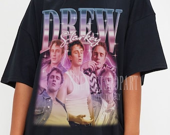 May include: Black oversized t-shirt with a graphic print of a band called "Drew Starkey". The print features a group of five men in a retro style with a pink and purple gradient.