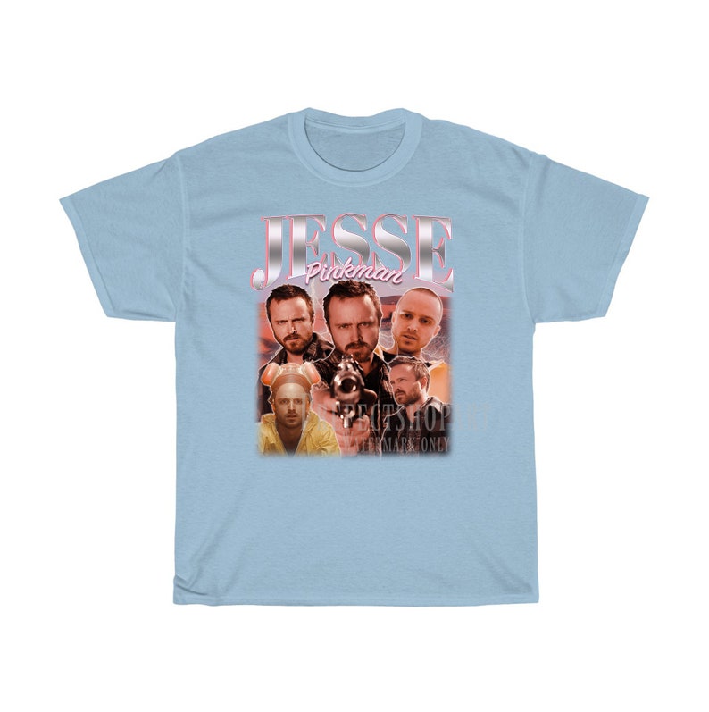 May include: Light blue t-shirt with a vintage-style graphic of Jesse Pinkman from the TV show Breaking Bad. The graphic features multiple images of Jesse Pinkman in different scenes from the show.