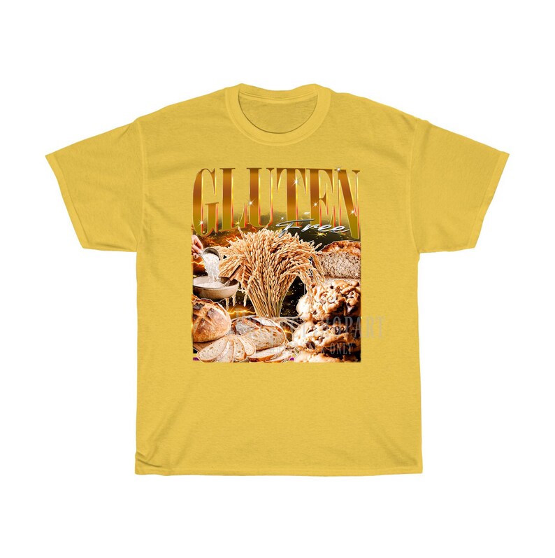 May include: Mustard yellow t-shirt displaying the word "GLUTEN" in gold, with an image of bread and wheat. The words "gluten free" are also visible. The shirt is made of a soft, comfortable material.