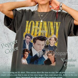 May include: Pepper-colored unisex t-shirt featuring a gold-colored "Johnny Depp" graphic with multiple images of the actor. The shirt has a vintage look and feel, with the text "Comfort Colors" on the side.