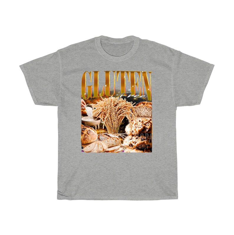 May include: A grey t-shirt with a graphic that reads "GLUTEN FREE" in gold. The graphic shows different types of bread and wheat, suitable for those with dietary restrictions.
