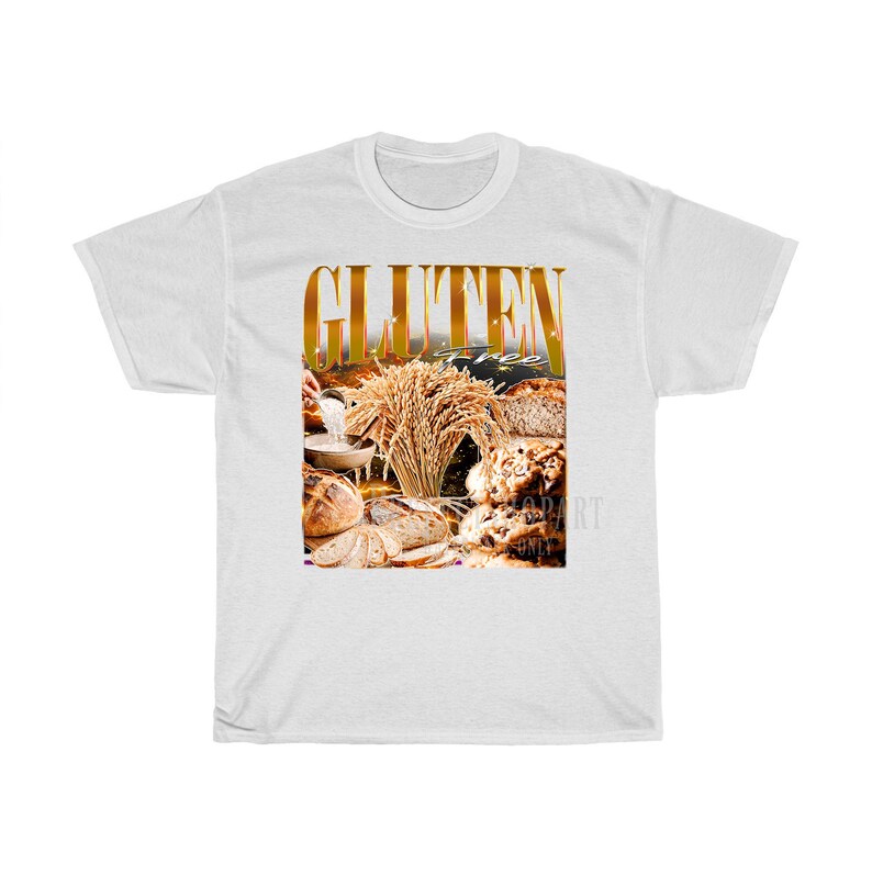 May include: White t-shirt with a gold graphic that reads "GLUTEN FREE". The graphic shows different types of bread, wheat, and baked goods. The shirt is made of a soft, comfortable material. The shirt is a standard fit.