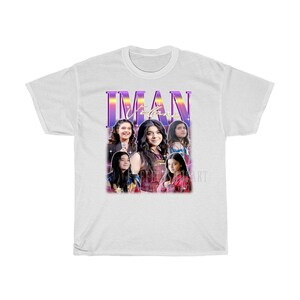 May include: White t-shirt with a retro-style graphic featuring a group of young women with the text "IMAN" in a purple and pink gradient.