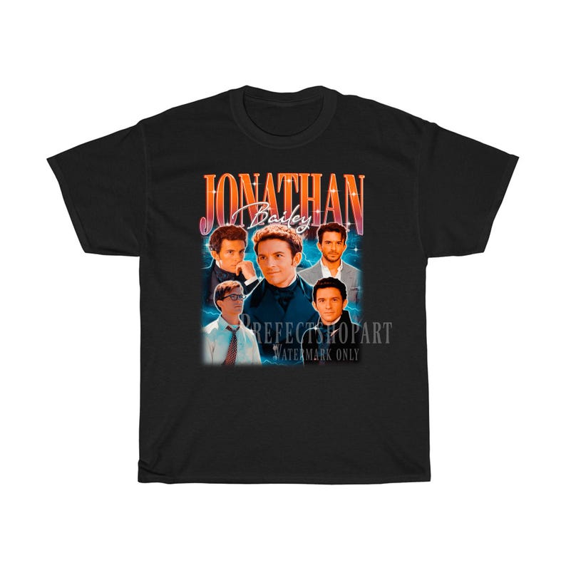 Peut inclure: T-shirt noir avec un graphique r&eacute;tro repr&eacute;sentant un groupe d'hommes avec le texte "Jonathan Bailey" dans une police color&eacute;e.