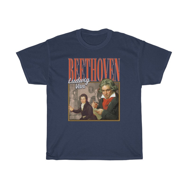 Pu&ograve; includere: Una t-shirt blu navy con una grafica in stile vintage di Ludwig van Beethoven. La grafica presenta un ritratto di Beethoven e il testo "BEETHOVEN" in rosso e bianco.