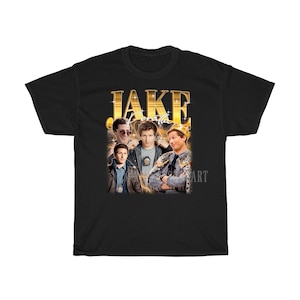 May include: Black t-shirt with a gold graphic of Jake Peralta from the TV show Brooklyn Nine-Nine. The graphic features Jake Peralta in different poses, including one with a crown.