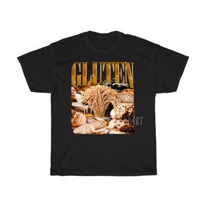 May include: Black t-shirt with a graphic featuring the words "GLUTEN FREE" in gold lettering. The graphic includes images of various types of bread, wheat, and a bowl of flour, all in warm, natural tones.