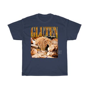 May include: A navy blue t-shirt with a gold-coloured graphic that reads "GLUTEN FREE". The graphic shows different types of bread and wheat, indicating a theme of gluten-free products.