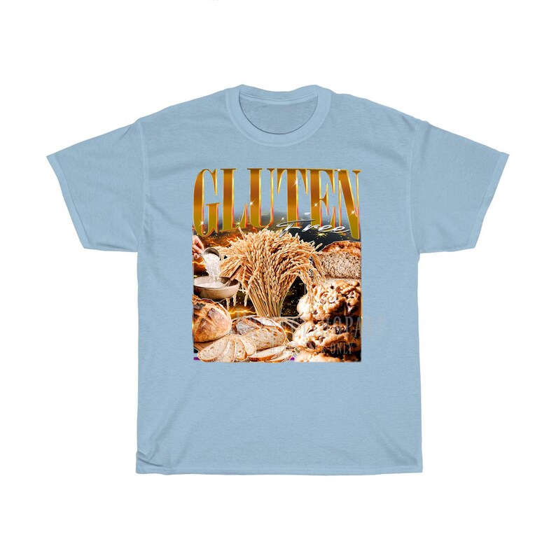 May include: Pale blue t-shirt featuring the words "GLUTEN FREE" in gold. The graphic shows different types of bread, wheat, and a bowl of flour. The shirt is made of a soft, comfortable material.
