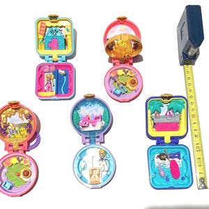 以下が含まれることがあります： 8つのミニチュアプラスチック製のおもちゃの家。それぞれ色が異なり、デザインも異なります。家は閉まっており、中にはさまざまなシーンが描かれています。