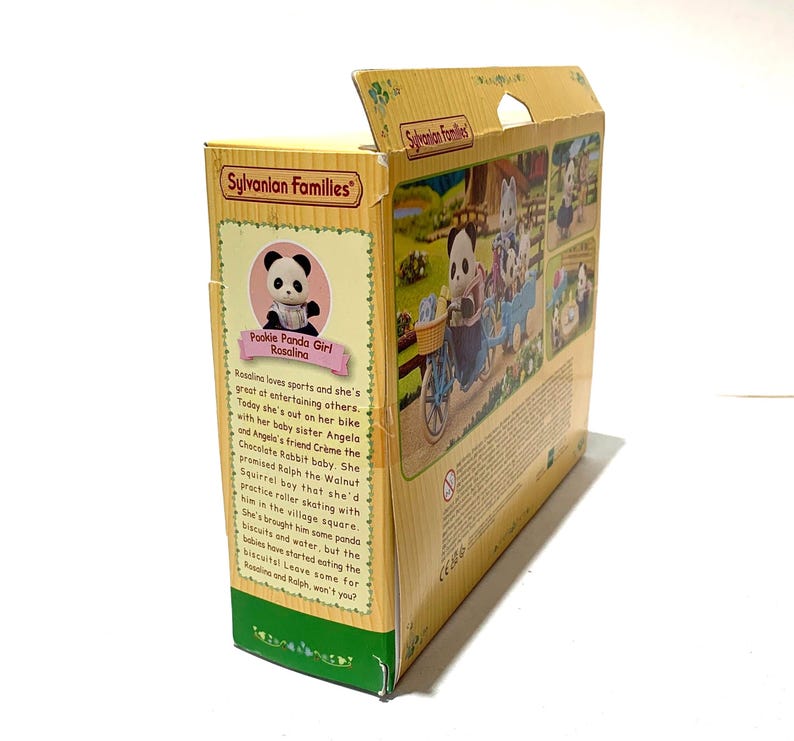 May include: A yellow Sylvanian Families cardboard toy box featuring a Pookie Panda Girl character named Rosalina. The packaging displays illustrations of panda figures on a bicycle, descriptive text about the characters, and the Sylvanian Families logo.