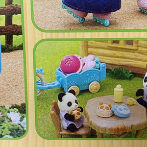 May include: A set of miniature flocked animal figures including a white rabbit and two pandas. The scene features a blue toy wagon, a wooden-style table with small food items, a yellow bottle, and a small chair, all displayed on a green surface.