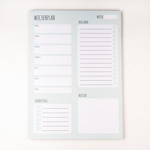 May include: A light blue weekly planner with sections for meals, tasks, birthdays, and notes. The planner has the text "Wochplan" at the top.
