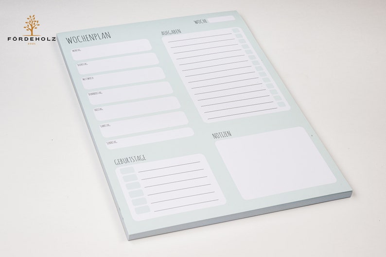 May include: A light blue weekly planner notepad with sections for "Wochenplan" (weekly plan), "Aufgaben" (tasks), "Woche" (week), "Geburtstage" (birthdays), "Notizen" (notes).