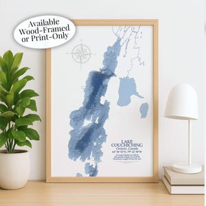 May include: A framed print of Lake Couchiching in Ontario, Canada, with a detailed blue and white topographical map. The print is in a light wood frame and includes a compass rose graphic. Text on the print reads "Lake Couchiching" and provides coordinates and depth measurements.