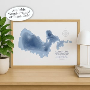 May include: A framed print of Golden Lake, Ontario, featuring a blue topographic map. The print includes the lake's coordinates and depth details. Text on the print reads "Available Wood-Framed or Print-Only." The average depth is 11 m.