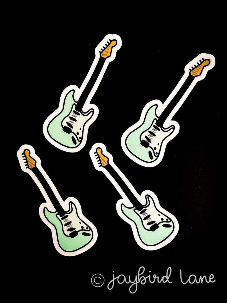 May include: Four mint green electric guitar stickers with black outlines and yellow tuning pegs. The stickers are on a black background. The text "jaybird lane" is in the bottom right corner.