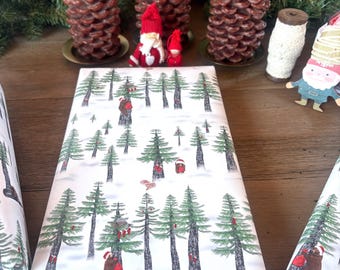 Papel de regalo navideño con un encantador bosque lleno de Papá Noel, osos, conejitos, cervatillos y búhos.