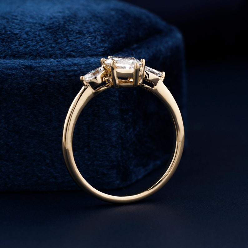 Pu&ograve; includere: Un anello con fascia in oro con tre diamanti di forma ovale. Il diamante centrale &egrave; pi&ugrave; grande dei due diamanti laterali.
